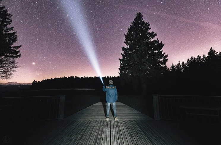 Lumière projetée vers un ciel étoilé.
